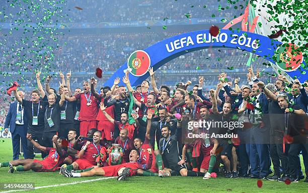 Portugal's players pose with the trophy as they celebrate after beating France during the Euro 2016 final football match at the Stade de France in...