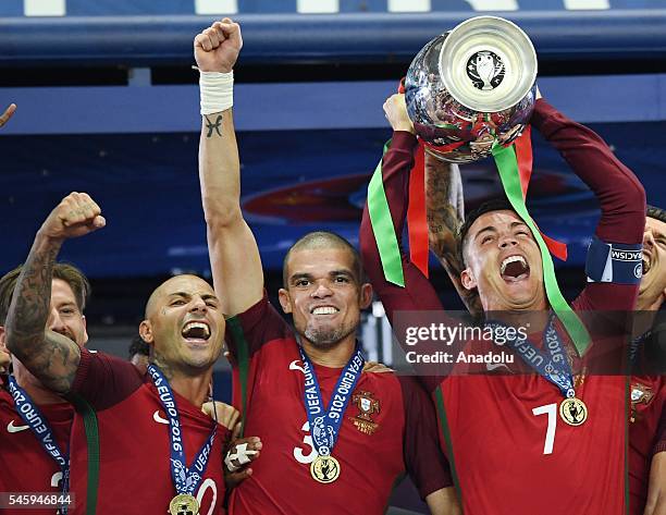 Portugal's forward Cristiano Ronaldo hold up the winners' trophy as he celebrates with teammates Portugal's forward Ricardo Quaresma , Portugal's...