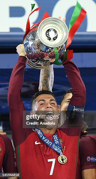 Portugal's forward Cristiano Ronaldo celebrates with the trophy as he poses after Portugal won the Euro 2016 final football match between Portugal...