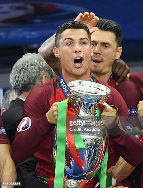 Portugal's forward Cristiano Ronaldo celebrates with the trophy as he poses after Portugal won the Euro 2016 final football match between Portugal...