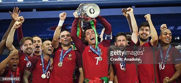Portugal's forward Cristiano Ronaldo hold up the winners' trophy as he celebrates with teammates Portugal's forward Ricardo Quaresma, Portugal's...