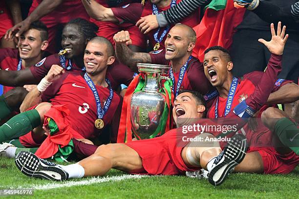 Portugal's players pose with the trophy as they celebrate after beating France during the Euro 2016 final football match at the Stade de France in...