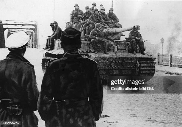 Ostfront - Abwehrkämpfe im Baltikum: Panzer VI 'Tiger' mit aufgesessenen Fallschirmjägern nach dem passieren einer Flussbrücke einer litauischen...