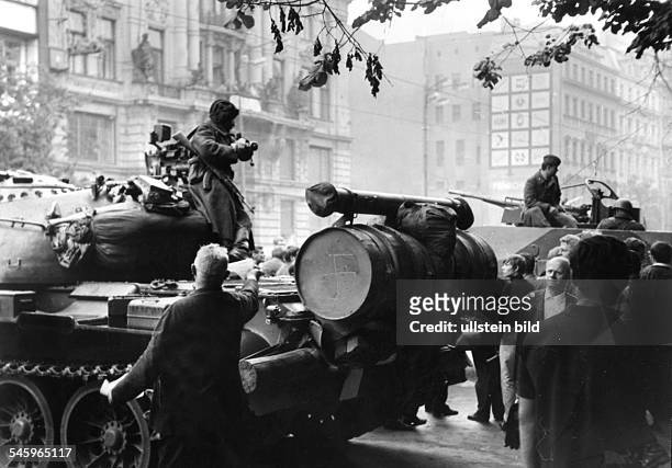 Prague Spring - Suppression Invasion of Czechoslovakia by troops of the Warsaw Pact countries| Soviet tanks at Weceslas Square in Prague| a local is...
