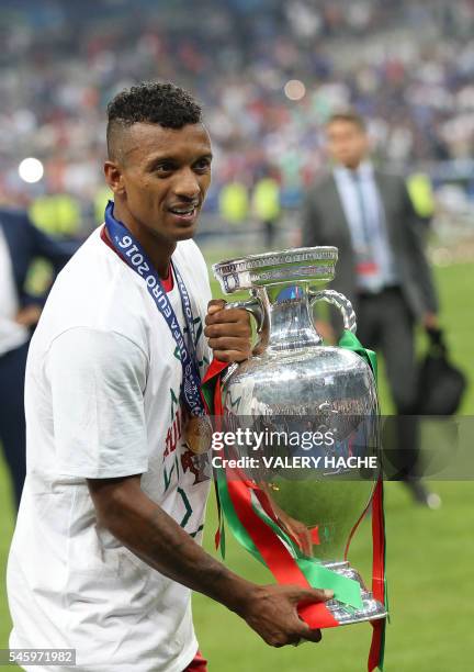 Portugal's forward Nani poses with the trophy as he celebrates after Portugal beat France during the Euro 2016 final football match at the Stade de...