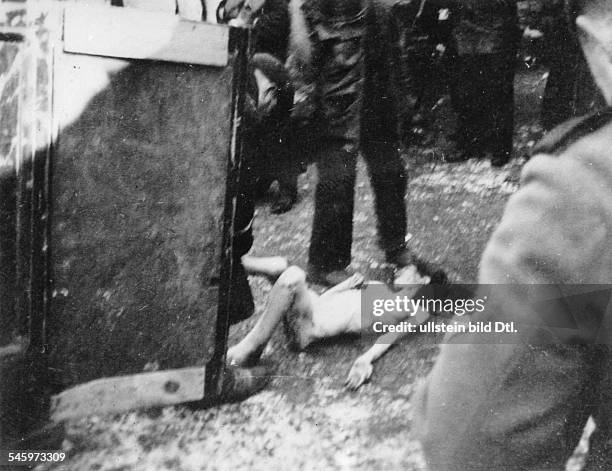 World War II, Warsaw Ghetto during the German occupation:the dead body of a woman is carried off.