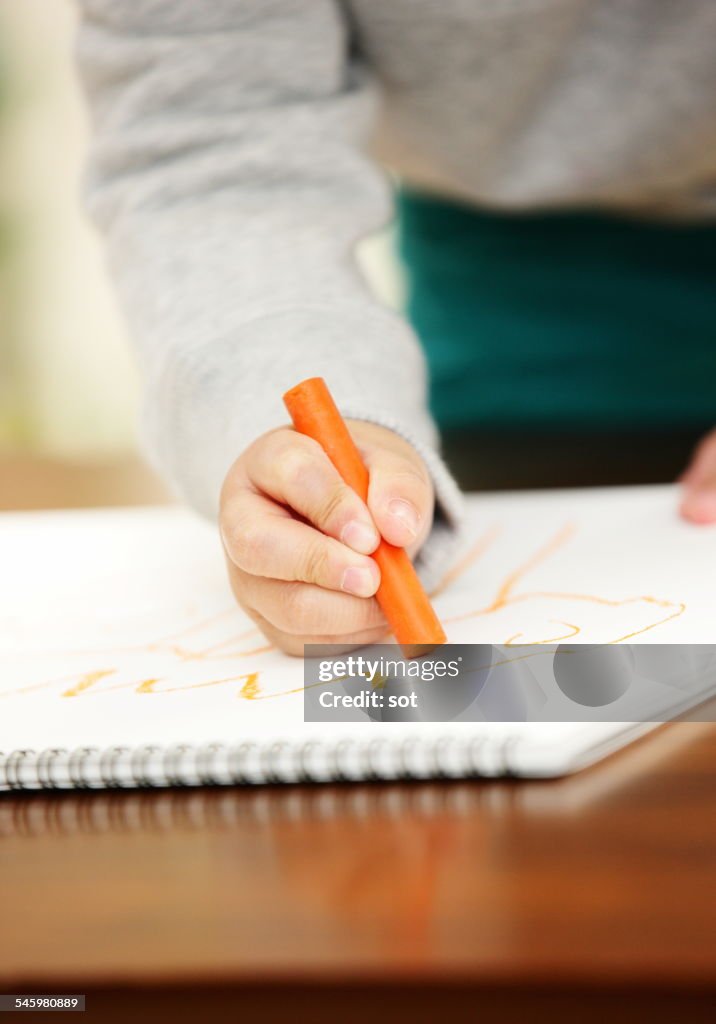 Baby boy drawing with crayons,close up