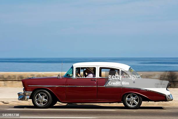 vintage american car speeding along the malecon in havana, cuba - 1950 2016 stock pictures, royalty-free photos & images