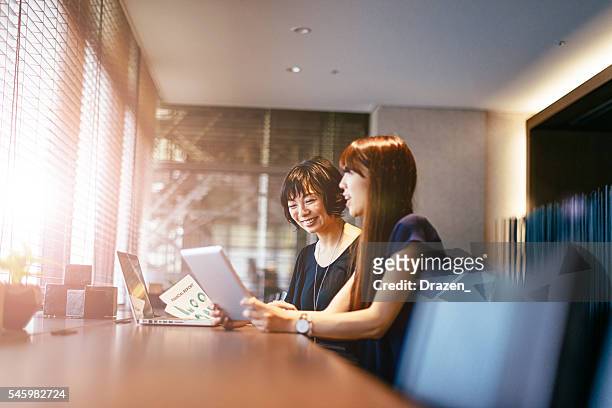 bild der lächelnden japanischen erfolgreichen geschäftswelt bei der arbeit - financial statements stock-fotos und bilder