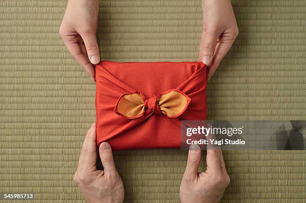 gift wrapped in japanese wrapping cloth (furoshiki - passing giving stockfoto's en -beelden