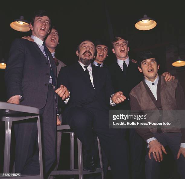 English pop group The Dave Clark Five posed with record producer and record company executive, Mitch Miller circa 1964. From left to right: Rick...