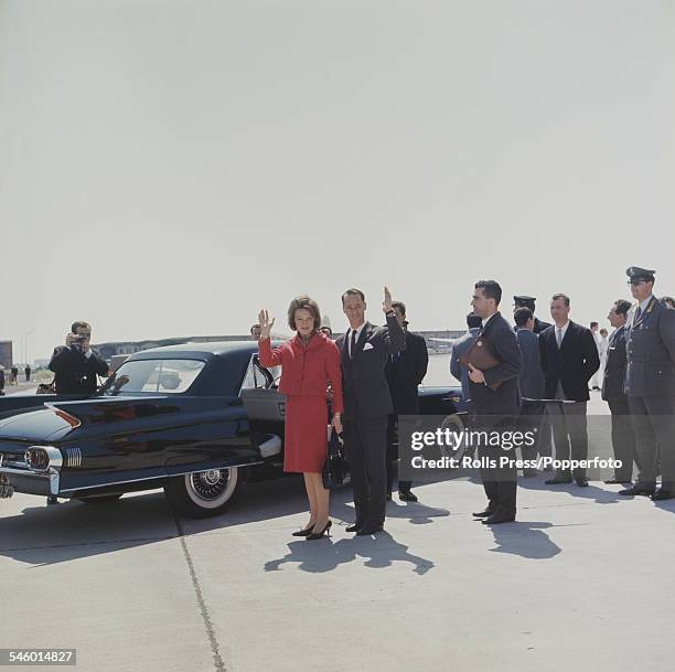 Princess Irene of the Netherlands pictured with future husband Carlos Hugo, Duke of Parma standing together beside a limousine car at an airport as...