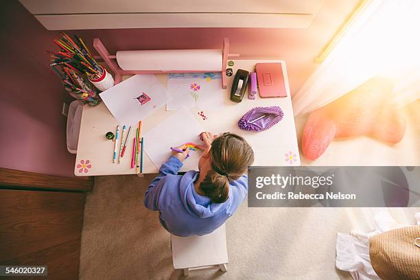 girl drawing at desk - child and unusual angle stock-fotos und bilder