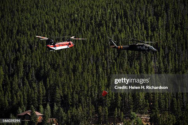 Helicopters head toward Barker Reservoir to fill up their buckets with water to make water drops on hotspots as the Cold Springs Fire continues to...