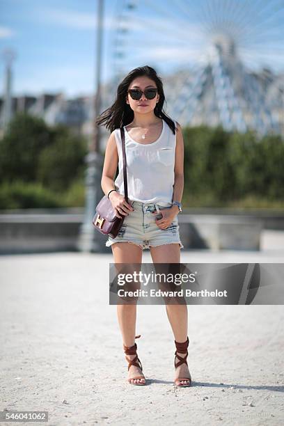 May Berthelot , is wearing a The Kooples top, an Iro short, Asos sandals, a Hermes Constance bag, sunglasses, and a necklace from Nine Avril Paris,...