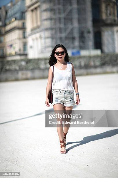 May Berthelot , is wearing a The Kooples top, an Iro short, Asos sandals, a Hermes Constance bag, sunglasses, and a necklace from Nine Avril Paris,...