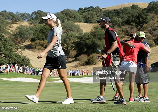 Anna Nordqvist of Sweden walks off the 18th green after she was assessed a two stroke penalty for grounding her club in a bunker on the 17th hole,...