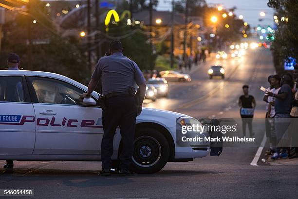 Baton Rouge police redirect traffic away from a protest march that resulted in scores of arrests after a march on July 10, 2016 in Baton Rouge,...