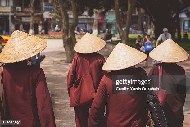 woman in traditional clothes and conical hat in the streets of hanoi, vietnam - hot vietnamese women stock pictures, royalty-free photos & images