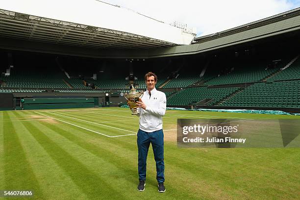 Andy Murray of Great Britain revisits centre court with the trophy at Wimbledon on July 11, 2016 in London, England.