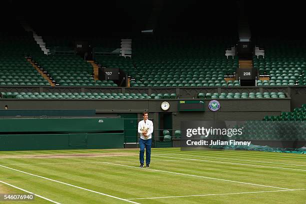 Andy Murray of Great Britain revisits centre court with the trophy at Wimbledon on July 11, 2016 in London, England.