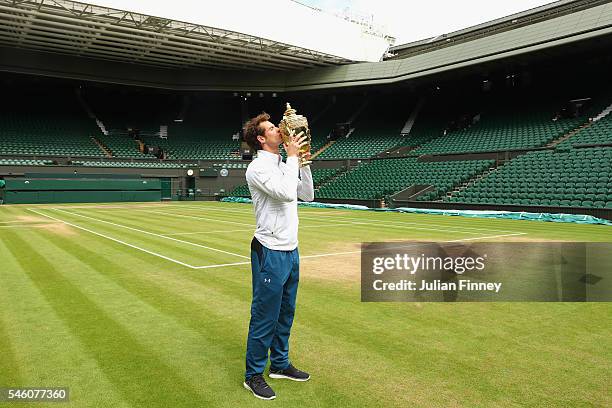 Andy Murray of Great Britain revisits centre court as he kisses the trophy at Wimbledon on July 11, 2016 in London, England.