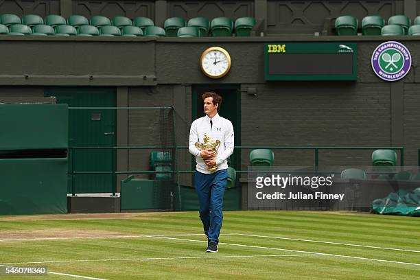 Andy Murray of Great Britain revisits centre court with the trophy at Wimbledon on July 11, 2016 in London, England.