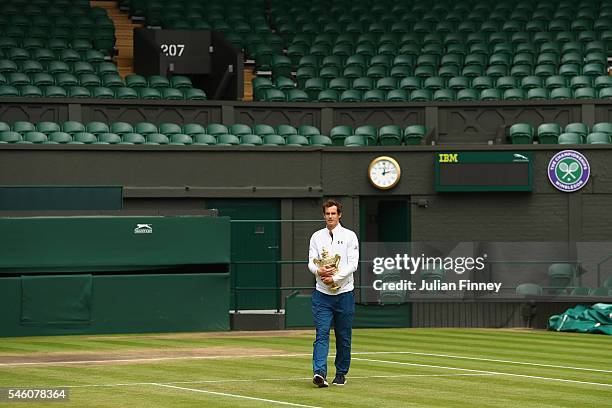 Andy Murray of Great Britain revisits centre court with the trophy at Wimbledon on July 11, 2016 in London, England.