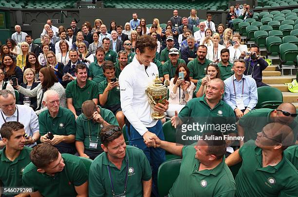 Andy Murray of Great Britain revisits centre court and meets members of the ground staff at Wimbledon on July 11, 2016 in London, England.
