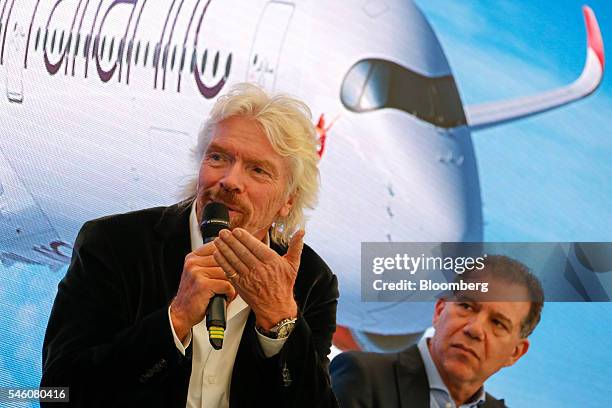 Richard Branson, billionaire and founder of Virgin Group Ltd., left, gestures whilst speaking as Craig Kreeger, chief executive officer of Virgin...