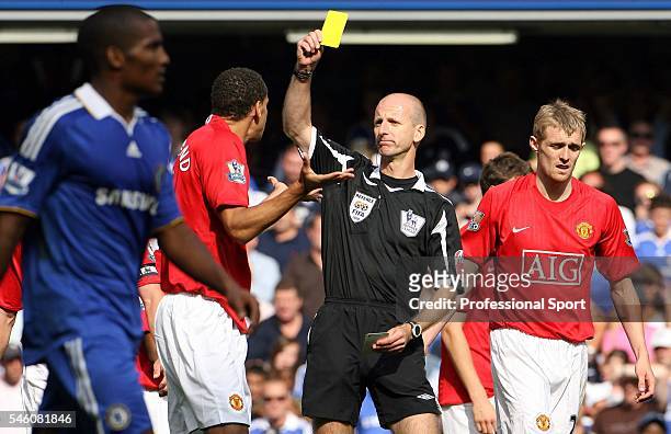 Rio Ferdinand receives a yellow card from referee Mike Riley during the Barclays Premier League match between Chelsea and Manchester United at...