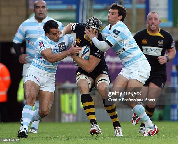 Nic Berry of London Wasps is held by Will Matthews and Jonathan Wisniewski of Racing Metro during the Amlin Challenge Cup match between London Wasps...