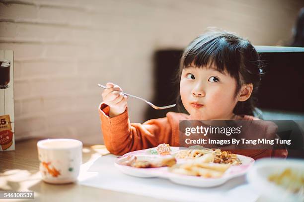 little girl having meal in restaurant - enjoying food stock pictures, royalty-free photos & images