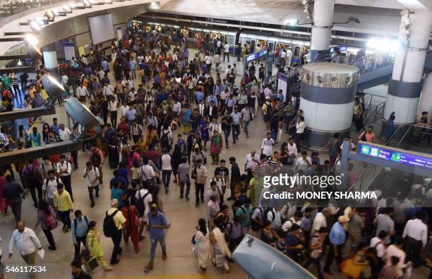 Indian commuters make their way through a metro station at rush hour in New Delhi on July 11 on World Population Day. - Indias population of 1.3...