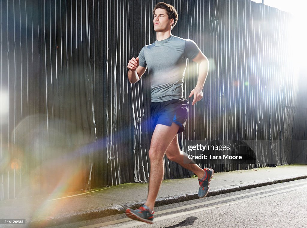 Man running on sunny street in urban setting