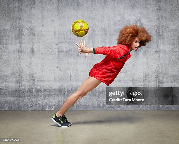 sportswoman with football suspended in motion - eccentric woman stock pictures, royalty-free photos & images