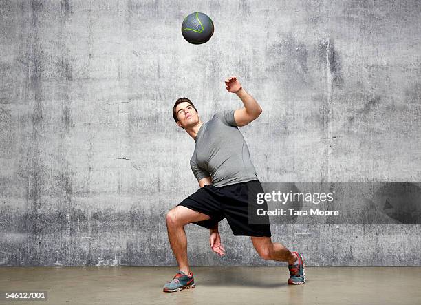 sportsman catching ball in urban studio setting - throwing fotografías e imágenes de stock