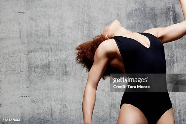 female dancer bending back in urban setting - leotard stockfoto's en -beelden