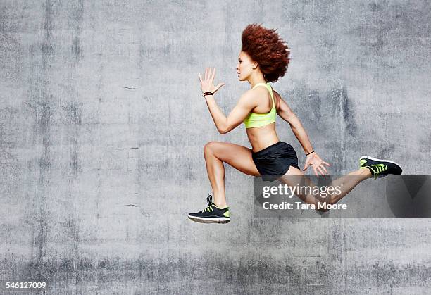 woman jumping in air in urban studio - leap stock pictures, royalty-free photos & images