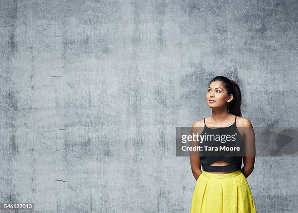woman in elegant dress in front of concrete wall - woman in spaghetti straps stock pictures, royalty-free photos & images