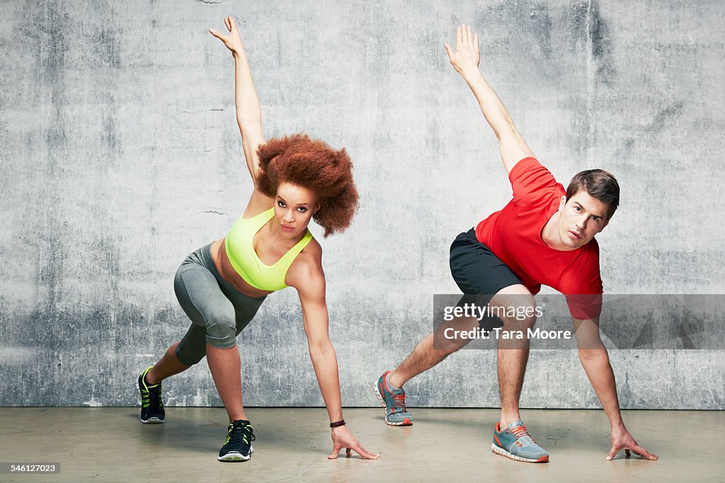 Young man and woman exercising in urban studio