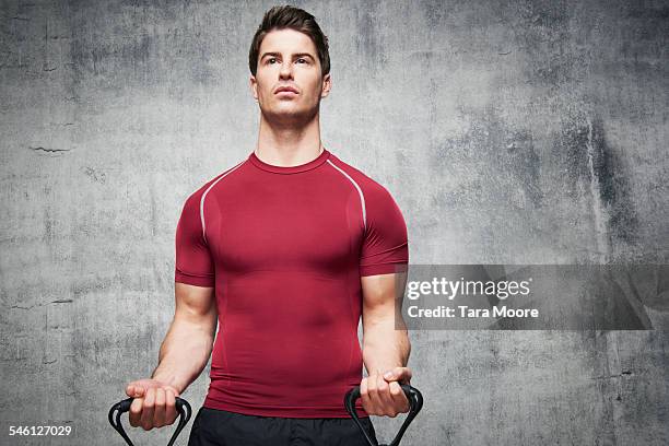 man exercising with stretch band in urban studio - handsome stock pictures, royalty-free photos & images