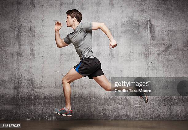 mal runner jumping in the air in urban studio - running shorts fotografías e imágenes de stock