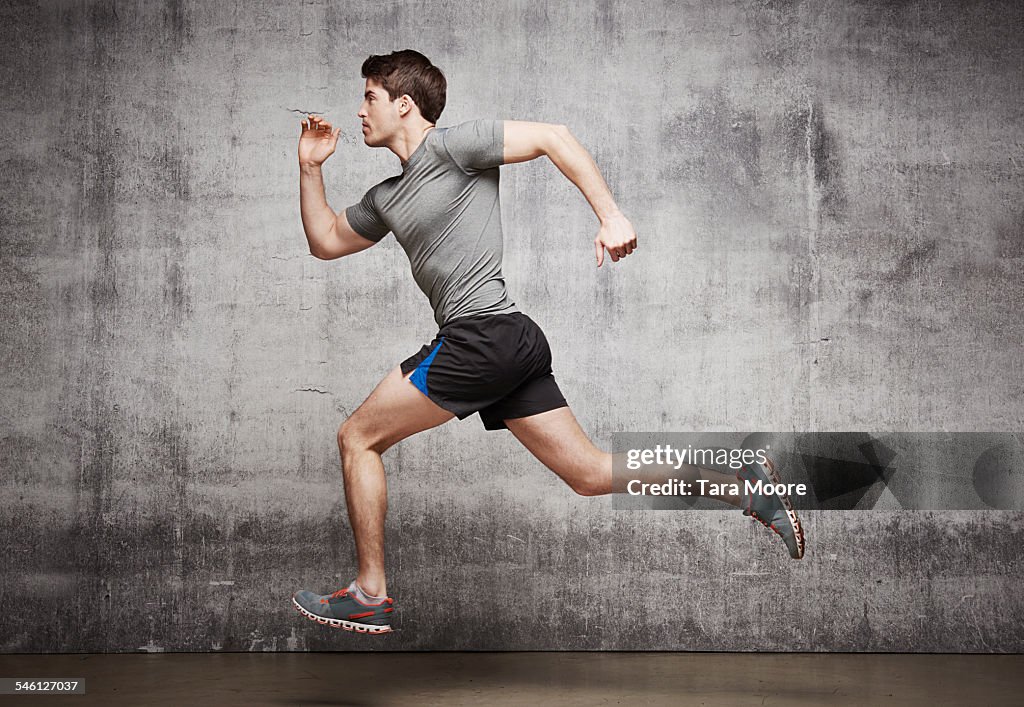 Mal runner jumping in the air in urban studio