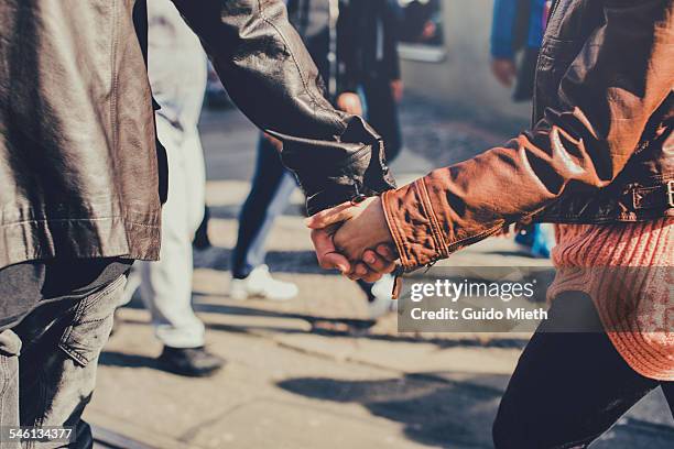 hand in hand going couple. - holding hands stock-fotos und bilder