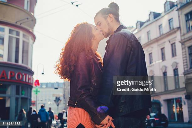 couple kissing in city. - キス ストックフォトと画像