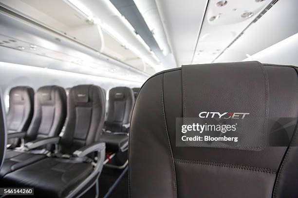 The CityJet Ltd. Logo hangs on a headrest on the seat of a Sukhoi Superjet 100 aircraft, manufactured by Sukhoi Civil Aircraft Co., on the opening...