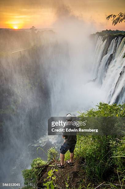 tourist gazing at victoria falls - victoria falls sunset stock pictures, royalty-free photos & images