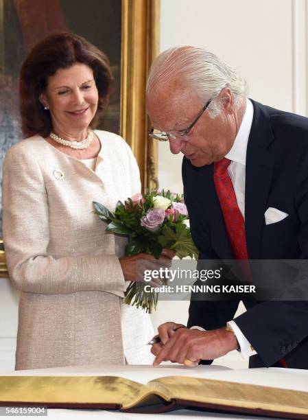 King Carl XVI Gustaf of Sweden and Queen Silvia of Sweden sign a guest book on July 11, 2016 at the townhall in Aachen. / Germany OUT