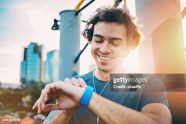 athlete checking his smart watch - wristwatch stockfoto's en -beelden